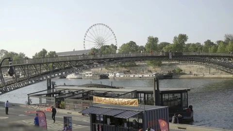 Ferris Wheel Roue de Paris and people crossing bridge in Paris France slow Stock Footage 94059122