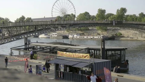 Ferris Wheel Roue de Paris spinning people walking across bridge River Paris Stock Footage 94059500