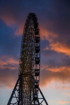 Ferris wheel silhouette at sunset with dramatic clouds Foto stock