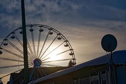 Ferris wheel silhouette at sunset with dramatic sky and amusement park stru.. Stock Photos