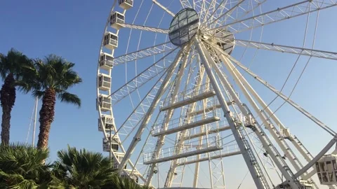 Ferris wheel, slow movement of cabins, against a blue sky Stock Footage 139829181