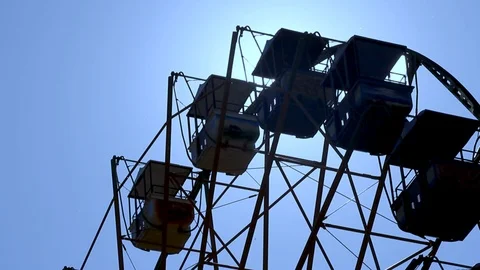 Ferris wheel spin, sun rays shining through, amusement park on a sunny day Video stock 116717124