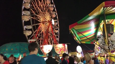 Ferris wheel spinning as crowd walks around below Vídeos de archivo 73433083