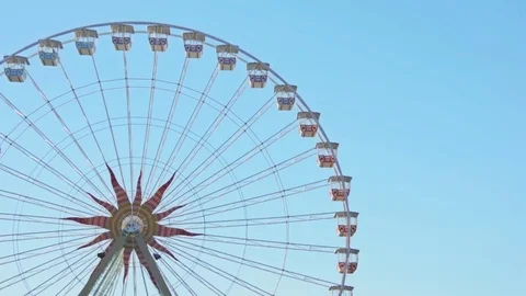 Ferris Wheel spins clockwise. Clean blue sky background. Stock Footage 83843538