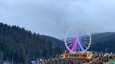 Ferris wheel standing still in mountain scenery Stock Footage 312878973