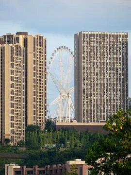 Ferris wheel visible between the gap of two high rise buildings. Stock Photos