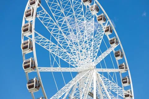 Ferris Wheel white construction structure on blue sky background Stock Photos