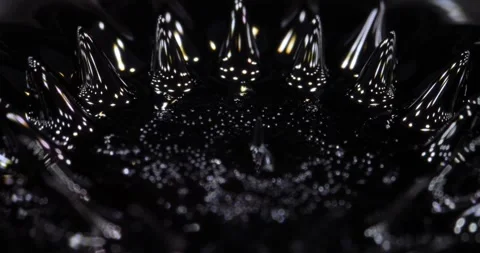 Ferrofluid tinted with colored paints. The surface of the black liquid. Abstract Stock Footage 272828377