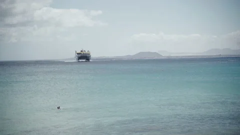 Ferry approaching while a person is swimming Stock Footage 235677014