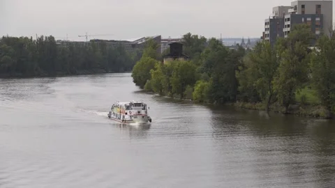A ferry boat sails up a river lined with trees - top view Stock Footage 277904871
