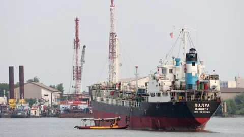 A ferry carrying a sailor on a moored ship on the Chao Phraya River Stock Footage 345344038