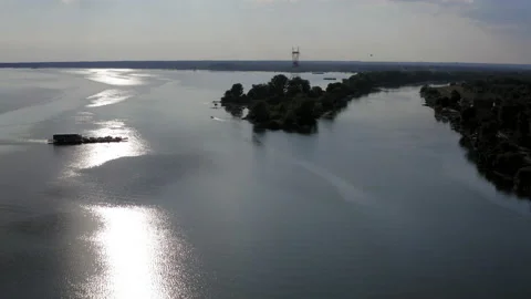Ferry crosses the Danube with the reflection of the sun on the water Видео 205594134