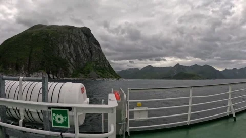 Ferry deck with liferaft container sailing past dramatic rocky cliff in Norway Vídeos de archivo 342755846