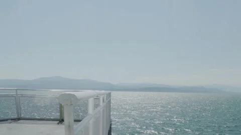 Ferry deck on ocean with mountains in background 動画素材 251940136
