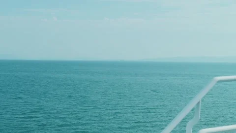 Ferry deck railing overlooking open turquoise ocean horizon 库存影片 336661317