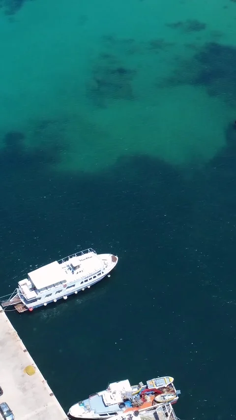 Ferry Docked at a Serene Harbor With Clear Blue Water in a Coastal Town 動画素材 311111852