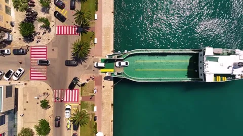 Ferry docking at terminal with vehicles and pedestrians at coastal area Stock Footage 338165061