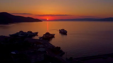 Ferry docking at Thasos port during sunset long aerial shot with golden sea 스톡 동영상 332557510