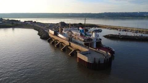 A ferry docks at dawn in a small harbor floating in the calm waters. Stock Footage 314471259