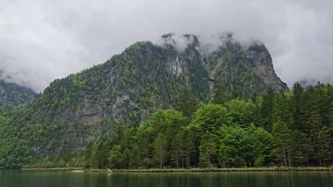 Ferry glides over the emerald waters of Lake Koenigssee, framed by lush pine  Stock Footage 309030962