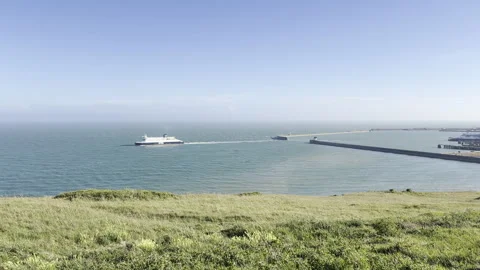 Ferry leaving port viewed from grassy hill panning Stock Footage 336516064