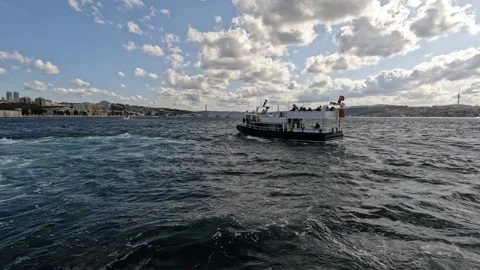 A ferry with passengers sails across the Bosphorus, adorned with Turkish flags Stock Footage 297626757