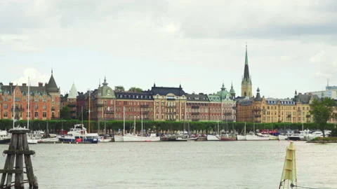 Ferry passes in front of old buildings in Stockholm Harbor Stock Footage 147911692