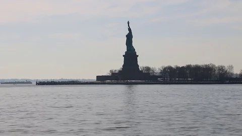 Ferry passes the Statue of Liberty, seen from the Battery in Manhattan Stock Footage 81007451