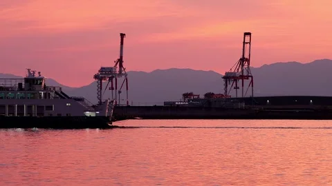 Ferry Passing in Front of Gantry Cranes in a Pink Sunset Japanese Harbor,4K 库存影片 341113315
