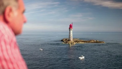 Ferry passing light house, man in foreground Stock Footage 83810306