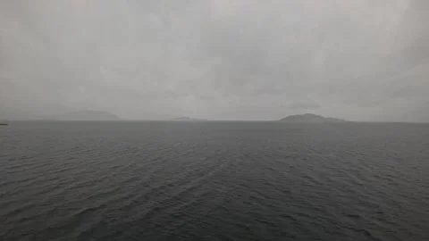 Ferry POV view of misty open ocean with distant island silhouettes in Norway Видео 341814625