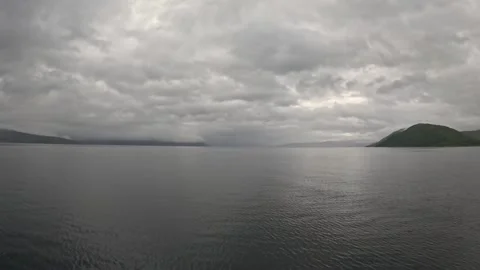 Ferry POV view of moody overcast clouds over calm fjord and mountains in Norway Stock-Footage 341814655