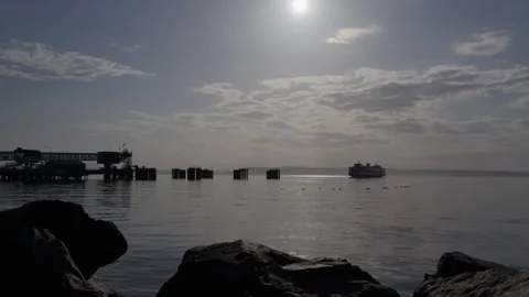 Ferry at sea under evening sun with rocks and cloudy sky Stock Footage 312771941