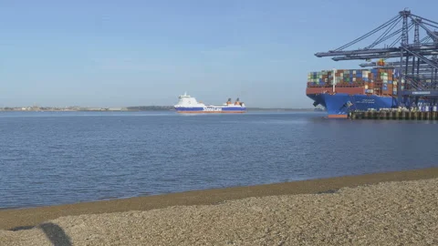Ferry Ship going out to sea &amp; container ship at port Felixstowe docks 库存影片 141734828
