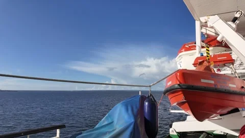 Ferry Side Deck and Orange Lifeboat Over Open Sea Vidéo 347684385
