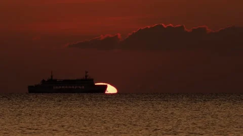 Ferry Silhouette Crossing Giant Setting Sun on Ocean Horizon at Sunset 動画素材 333900004