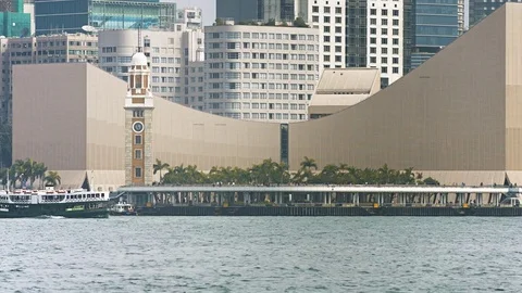Ferry transiting in front of the Tsim Sha Tsui clock tower. FullHD footage Stock Footage 74619276