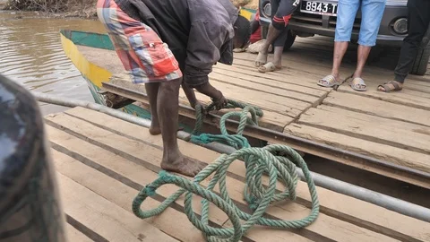 Ferry Worker Tying Up Raft on Local Ferry Boat, Mania River, Madagascar Stock Footage 117065450