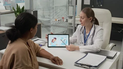Fertility Expert Pointing at Digital Tablet Explaining IVF Process to Woman Stock Footage 333688503