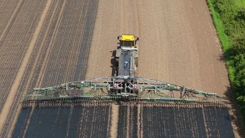 Fertilizer application machinery spreading organic slurry across cultivated Stock Footage 339342529