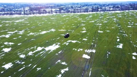 Fertilizer application, spring, winter wheat field, snow islands, solar glare Stock Footage 150248853