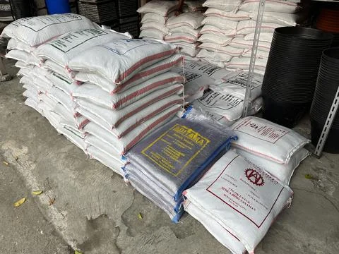 Fertilizer bag being stacked in front of a plant shop Stock Photos
