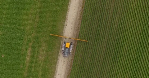 Fertilizer machine opening up its arms to spray chemicals on the green crops Stock Footage 81535167