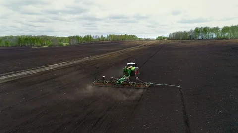 Fertilizing Soil and Preparing for Sowing. Tractor Working in Agricultural Farm Stock Footage 127982458