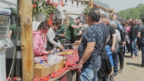 Festival crowds queue for hot tasty BBQ meats at busy catering stand Stock Footage 193368523