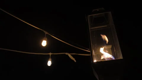 Festival decorative string lights and fire lamp, street lights glow outdoors at 스톡 동영상 304303515