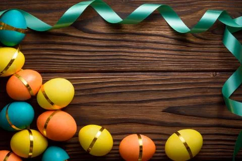 Festival frame from bright easter eggs and green ribbon Stock Photos