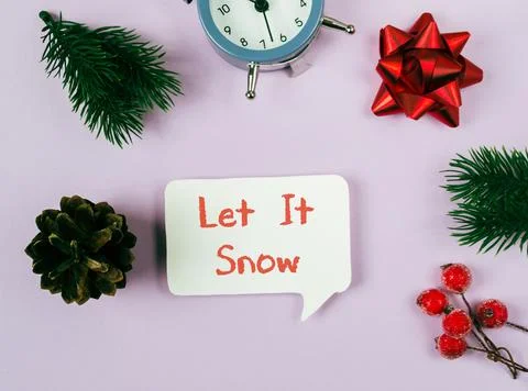 Festive arrangement featuring clock, pine branches, red bow, and decorative Stock Photos