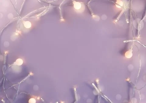 Festive backdrop for a postcard or web design. Frame made of a garland and bokeh Stock Photos