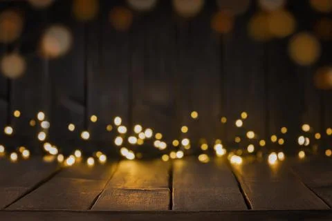 Festive background of dark brown table top with lights bokeh. Copy space Photos